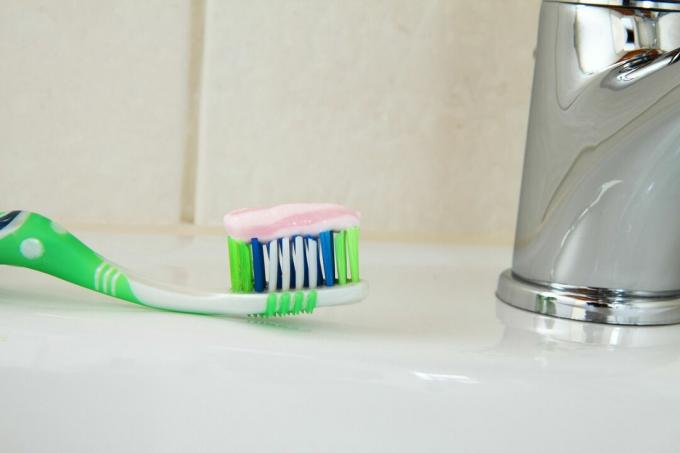 सिंक पर बैठे हुए टूथपेस्ट के साथ टूथब्रश को बंद करें।
