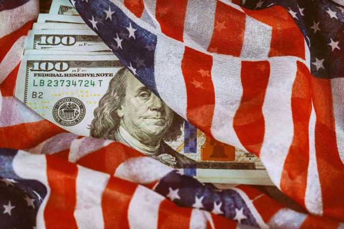 अमेरिकी ध्वज लगभग सौ डॉलर के नोटों में लिपटा हुआ है।