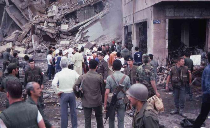 अमेरिकी दूतावास, बेरुत, लेबनान, 18 अप्रैल, 1983 के आत्मघाती बम विस्फोट के दृश्य के दौरान सैनिकों और सहायता गोताखोरों की भीड़ विनाश और क्षति के बीच खड़ी है।